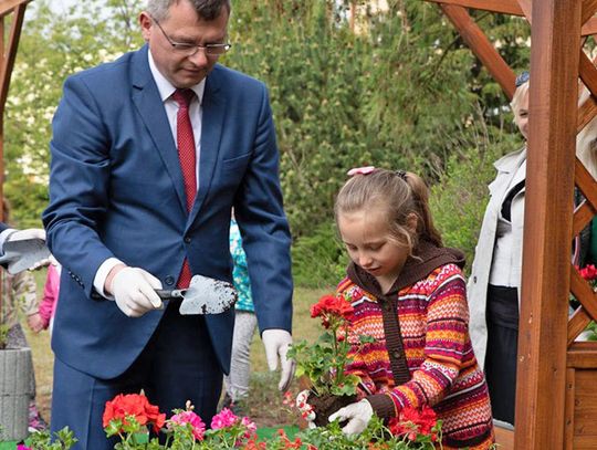 Tomasz Pisarek z zarządu powiatu pomaga dzieciom w sadzeniu kwiatów. Zdjęcia: Karolina Weiss